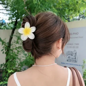 Woman wearing a white plumeria flower hair claw clip