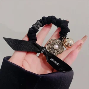 Black Velvet Scrunchies for Women Black velvet hair scrunchie resting in a woman’s hand