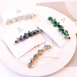 Crystal Sparkly Barrette Hair Clip Set for Women Set of four crystal sparkly barrette hair clips in green, blue, white and golden on a plate