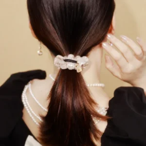 Woman wearing a golden satin organza mesh hair scrunchie in a ponytail