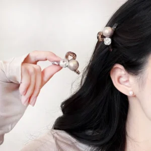 Woman wearing a pearl and rhinestone gem hair claw clip while holding another clip