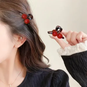 Woman wearing a maroon ball hair clip while holding another matching clip