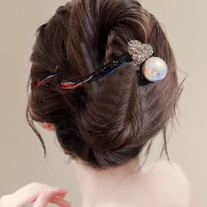 Woman wearing a plastic banana hair clip decorated with rhinestones and a pearl at the back of her hair